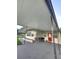 Covered carport area featuring seating, exterior storage and a red door at 33516 Arthur Dr, Wesley Chapel, FL 33543