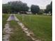 Gravel driveway leading to a property with a spacious yard and fenced perimeter at 33516 Arthur Dr, Wesley Chapel, FL 33543