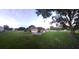 Inviting single-story home featuring a covered porch, set on a spacious lot with mature trees and lush green lawn at 33516 Arthur Dr, Wesley Chapel, FL 33543