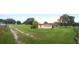 Charming single-story home with a bright red door and a well-maintained front yard, enhanced by mature trees at 33516 Arthur Dr, Wesley Chapel, FL 33543