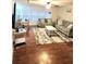 Bright living room with hardwood floors, comfortable seating, and a view of the dining area at 33516 Arthur Dr, Wesley Chapel, FL 33543