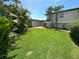 Large, manicured backyard with lush green grass and tropical landscaping, offering privacy at 3654 Corsair Ct, New Port Richey, FL 34652