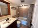 Neutral bathroom features a tub with tile surround and wood vanity with modern fixtures at 3654 Corsair Ct, New Port Richey, FL 34652