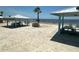 Sandy beach area with picnic tables and shade, perfect for relaxation and recreation at 3654 Corsair Ct, New Port Richey, FL 34652