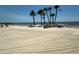 Picturesque sandy beach with palm trees and chairs, offering stunning ocean views at 3654 Corsair Ct, New Port Richey, FL 34652