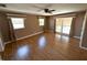 Spacious bedroom with wood floors, ceiling fan, and windows dressed in decorator fabric at 3654 Corsair Ct, New Port Richey, FL 34652