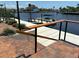 Waterfront view from paver patio, showing dock with boat lift and lush landscaping at 3654 Corsair Ct, New Port Richey, FL 34652