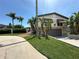 Stunning two-story home showcasing a stone facade, well-manicured lawn, and tropical landscaping in a sunny setting at 3654 Corsair Ct, New Port Richey, FL 34652