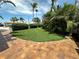 Well-manicured lawn with brick trim, mature trees, and green shrubbery offer privacy at 3654 Corsair Ct, New Port Richey, FL 34652