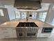Spacious kitchen featuring a large island with a professional gas range and a view of the living area and pool at 3654 Corsair Ct, New Port Richey, FL 34652