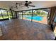 Enclosed pool with brick flooring, ceiling fans, and views of the landscaped yard and pool at 3654 Corsair Ct, New Port Richey, FL 34652