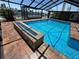 Beautiful in-ground pool featuring a water feature and brick surround within a screened enclosure at 3654 Corsair Ct, New Port Richey, FL 34652