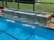 Close up view of the beautiful in-ground pool water feature and brick surround at 3654 Corsair Ct, New Port Richey, FL 34652