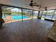 Enclosed pool area with brick flooring, fans, and views of the pool and waterway at 3654 Corsair Ct, New Port Richey, FL 34652