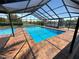 Beautiful in-ground pool with brick surround, screened enclosure, and views of the water at 3654 Corsair Ct, New Port Richey, FL 34652