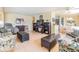 Bright living room with comfortable seating, ottomans, a media center and an adjacent dining area at 36750 Beth Ave, Zephyrhills, FL 33542