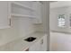 Bar area with marble countertops, open shelves, and gold hardware next to an unfurnished room at 4311 W Sevilla St, Tampa, FL 33629