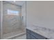 Bathroom featuring a tiled shower, stone vanity, and window offering natural light at 4311 W Sevilla St, Tampa, FL 33629