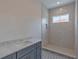 Bathroom featuring a tiled shower, stone vanity, patterned tile floor and a bright window at 4311 W Sevilla St, Tampa, FL 33629