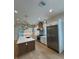 Modern kitchen with stainless steel refrigerator, marble counters, and custom range hood at 4311 W Sevilla St, Tampa, FL 33629
