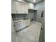 Laundry room with white cabinets, marble-style flooring, and a stainless steel sink at 4311 W Sevilla St, Tampa, FL 33629