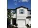 Two-story townhouse showcases a white exterior, complemented by vibrant landscaping under a clear blue sky at 4505 Globe Thistle Dr, Tampa, FL 33619