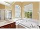Bright bathroom with a soaking tub, garden window, and vanity at 4508 Netherwood Dr, Tampa, FL 33624
