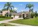 Charming home with well-manicured lawn, mature palm trees, and three-car garage at 4508 Netherwood Dr, Tampa, FL 33624