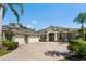 A beautiful home boasts an expansive driveway with a three car garage, manicured lawn, and lush landscaping at 4508 Netherwood Dr, Tampa, FL 33624
