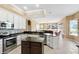 Well-equipped kitchen boasting white cabinetry, stainless steel appliances, and views of the living area at 4508 Netherwood Dr, Tampa, FL 33624