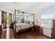 Bright main bedroom featuring a canopy bed, hardwood floors, and a sunny window at 4508 Netherwood Dr, Tampa, FL 33624