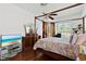 Bright main bedroom featuring a canopy bed, hardwood floors, and a sunny window at 4508 Netherwood Dr, Tampa, FL 33624