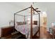 Well-lit main bedroom features wood floors, canopy bed, ceiling fan, and ensuite bathroom at 4508 Netherwood Dr, Tampa, FL 33624