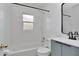 Bathroom showcasing a tiled shower/tub, a gray vanity, black mirror and faucet, and a toilet at 4706 E Sligh Ave, Tampa, FL 33610