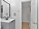 Bathroom featuring a gray vanity with a black faucet and mirror, and a doorway to another room at 4706 E Sligh Ave, Tampa, FL 33610