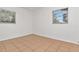 Bright bedroom featuring two windows with outside views and neutral tile flooring at 4706 E Sligh Ave, Tampa, FL 33610