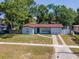 Charming single-story home with a well-maintained lawn and driveway, nestled under mature trees at 4706 E Sligh Ave, Tampa, FL 33610