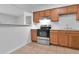 Traditional-style kitchen with wood cabinets, tile floors and stainless steel appliances at 4706 E Sligh Ave, Tampa, FL 33610