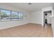 A well-lit living room featuring tile floors, large windows and a doorway to another room at 4706 E Sligh Ave, Tampa, FL 33610