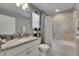 Well-lit bathroom featuring tiled shower/tub, granite countertop, and decorative toilet paper holder at 5026 Bromeliad Ave, Wimauma, FL 33598