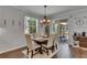 Bright dining room with wood table, chairs, slider to screened patio, and stylish chandelier at 5026 Bromeliad Ave, Wimauma, FL 33598