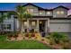Inviting home exterior with a landscaped yard, pillars, and a cozy front porch at 5026 Bromeliad Ave, Wimauma, FL 33598