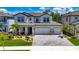 Beautiful two-story home with well-manicured landscaping, a three-car garage and elegant entryway at 5026 Bromeliad Ave, Wimauma, FL 33598
