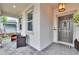 Inviting front porch features seating and stylish gray door and exterior, offering curb appeal at 5026 Bromeliad Ave, Wimauma, FL 33598