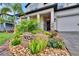 Landscaped front yard features stone address marker, plants, flowers and well-maintained lawn, enhancing curb appeal at 5026 Bromeliad Ave, Wimauma, FL 33598