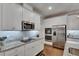 Modern kitchen featuring stainless steel appliances, granite countertops, tile backsplash, and wood flooring at 5026 Bromeliad Ave, Wimauma, FL 33598
