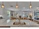 Open concept kitchen with granite counters, stainless appliances, and views into living and dining areas at 5026 Bromeliad Ave, Wimauma, FL 33598