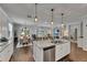 Open-concept kitchen and living area with hardwood floors, granite countertops, and stainless steel appliances at 5026 Bromeliad Ave, Wimauma, FL 33598