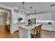 Bright kitchen featuring a central island, granite counters, white cabinetry, and stainless appliances at 5026 Bromeliad Ave, Wimauma, FL 33598
