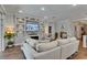 Comfortable living room featuring recessed lighting, hardwood floors, custom shelves, and a modern fireplace at 5026 Bromeliad Ave, Wimauma, FL 33598